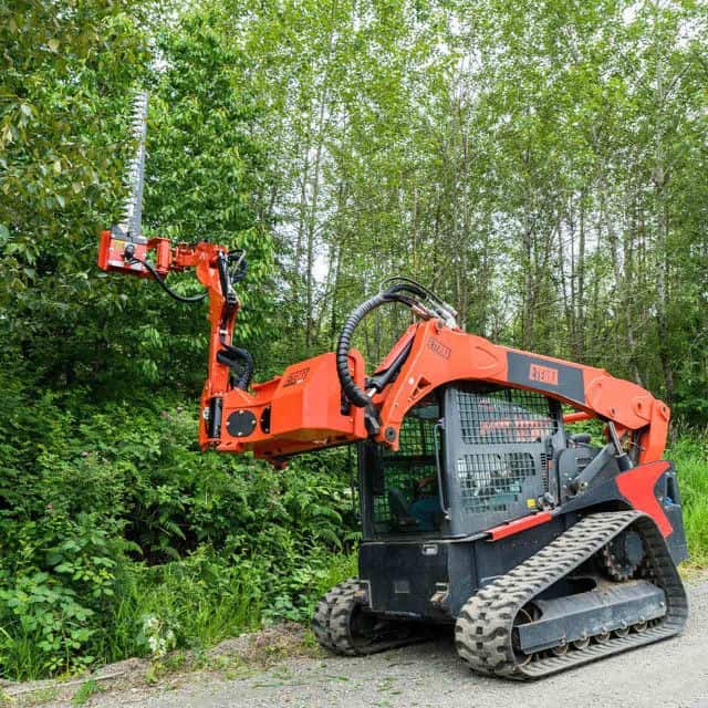 Eterra Raptor boom arm with 7 foot sickle bar cutting along tree line showing reach and trimming performance