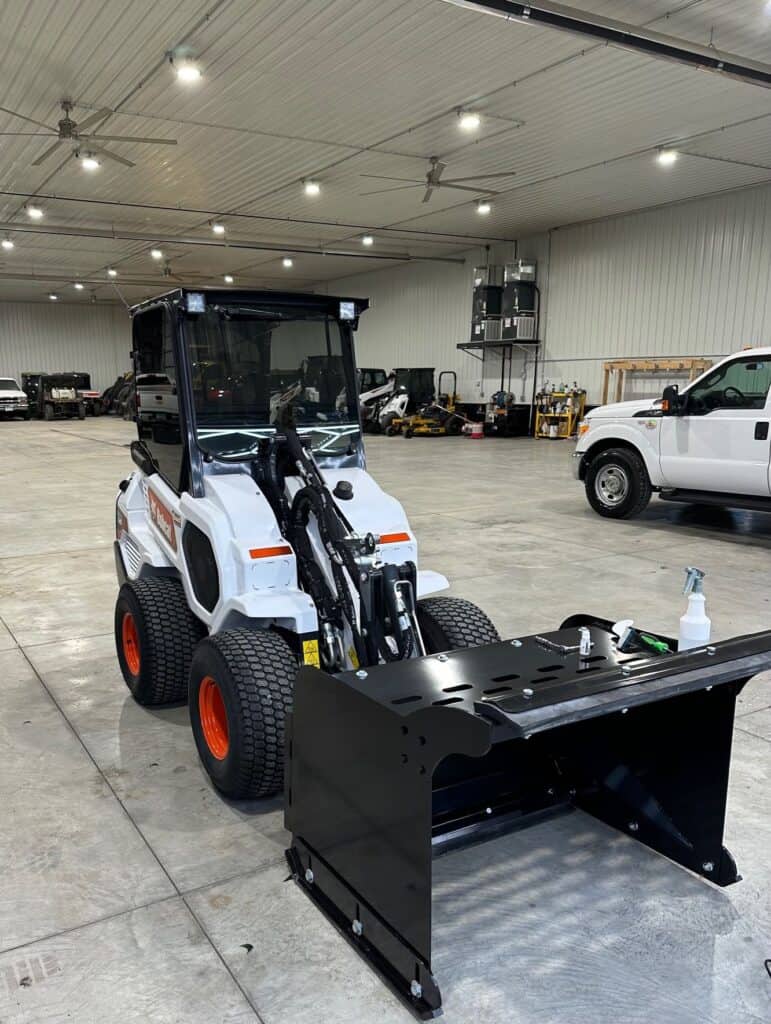 ECHO CTP compact tractor pusher attachment inside equipment shop ready for tractor mounting