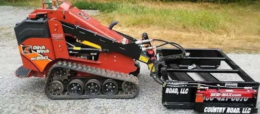 Skid-Max 3X mini skid steer dirt and gravel grader mounted on mini skid steer showing compact grading attachment in use
