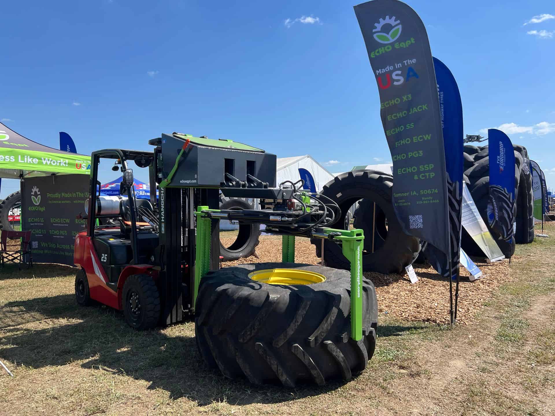 ECHO X3FL forklift tire grabber attachment lifting large agricultural tractor tire at outdoor equipment expo