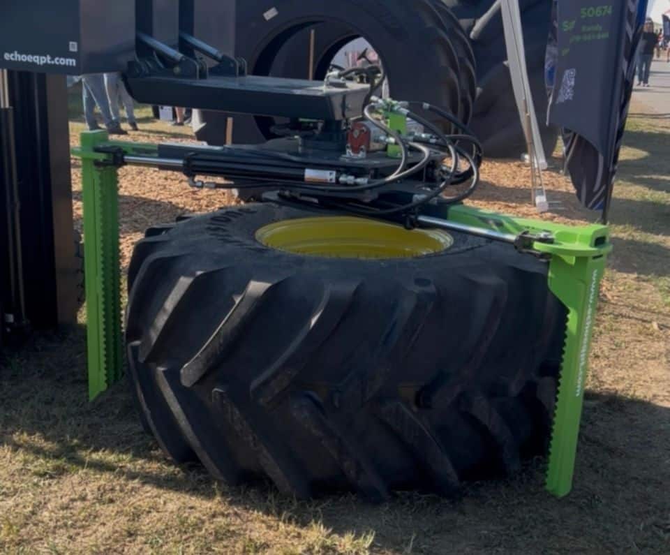 Forklift operating ECHO X3FL tire grabber attachment to move oversized tractor tire safely