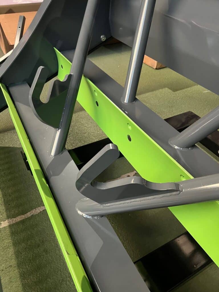 Inside frame structure of ECHO PG3 skid steer power grader showing blade adjustment system