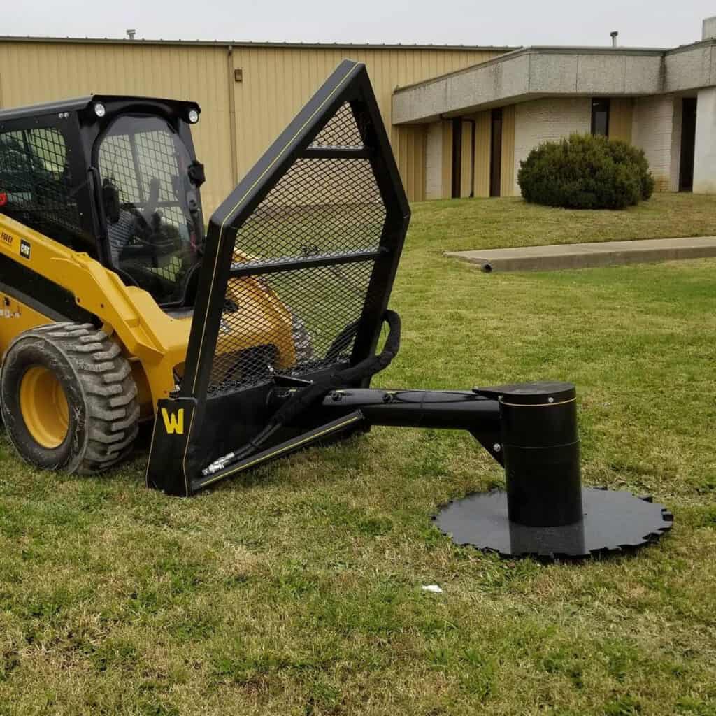 Side profile of M&M Hydra Saw skid steer tree saw attachment on CAT loader