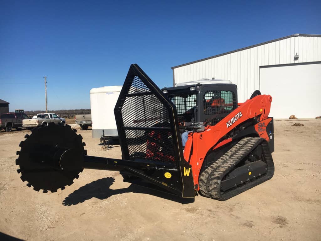 Side view of M&M Hydra Saw attachment mounted on Kubota SVL95 compact track loader