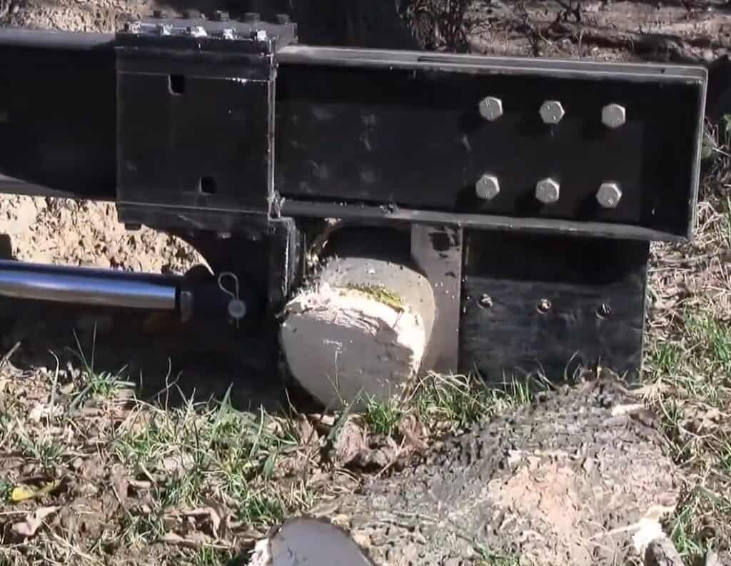 Close up of M&M Hydra Split skid steer log splitter hydraulic ram and wedge assembly