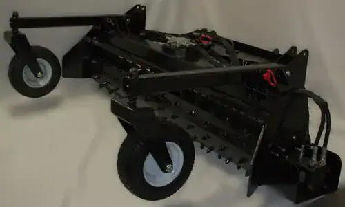 Prime Attachments skid steer soil conditioner left side view showing wheel kit and hydraulic drive system for grading