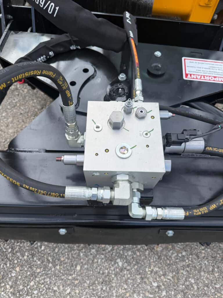 Close-up of PRIME soil conditioner hydraulic manifold, fittings and hoses