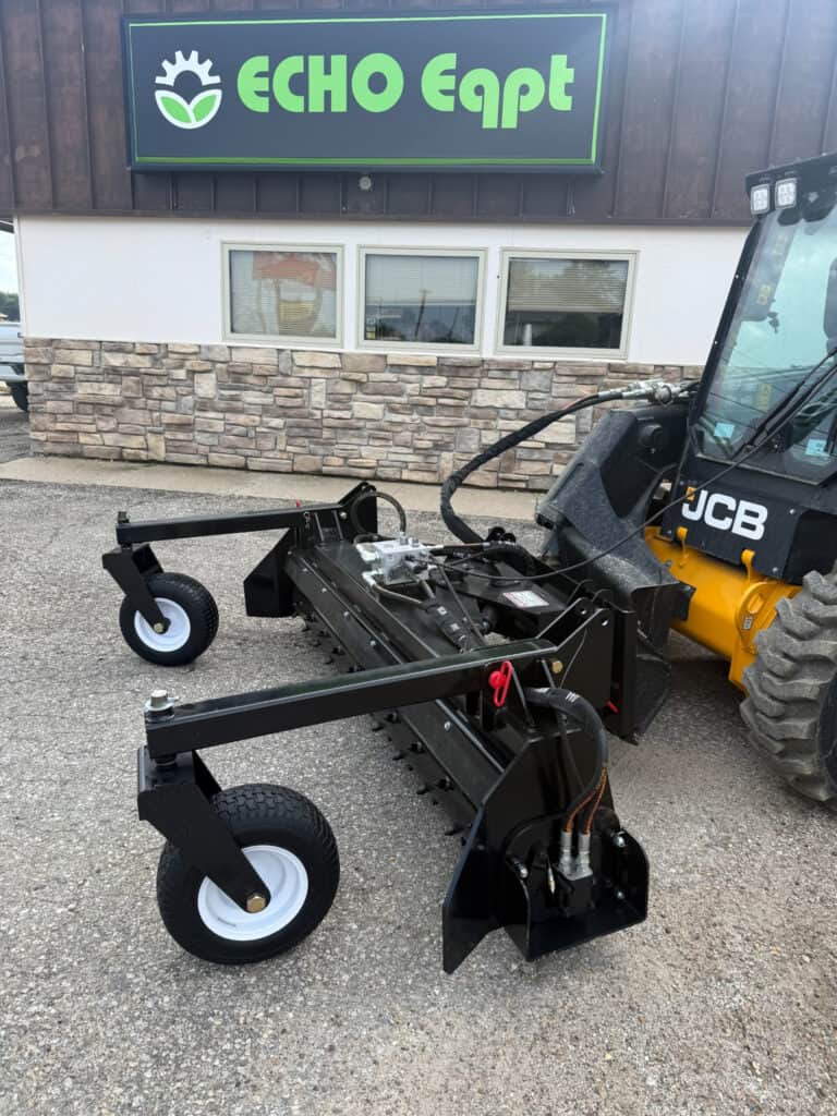 PRIME soil conditioner mounted on a JCB skid steer outside ECHO Eqpt with dual gauge wheels