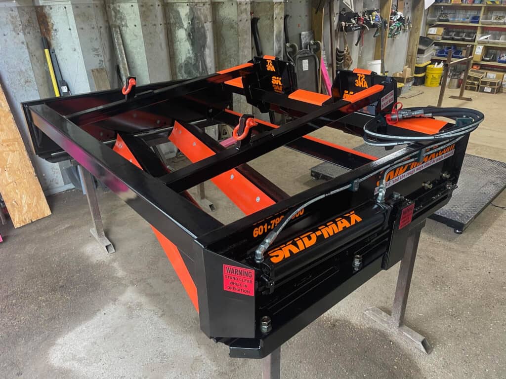 Front view of orange Skid Max 3 blade hydraulic skid steer grader attachment