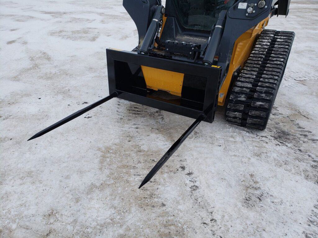 Stinger BS2 skid steer bale spear mounted on skid steer showing dual spear setup for lifting and moving round bales