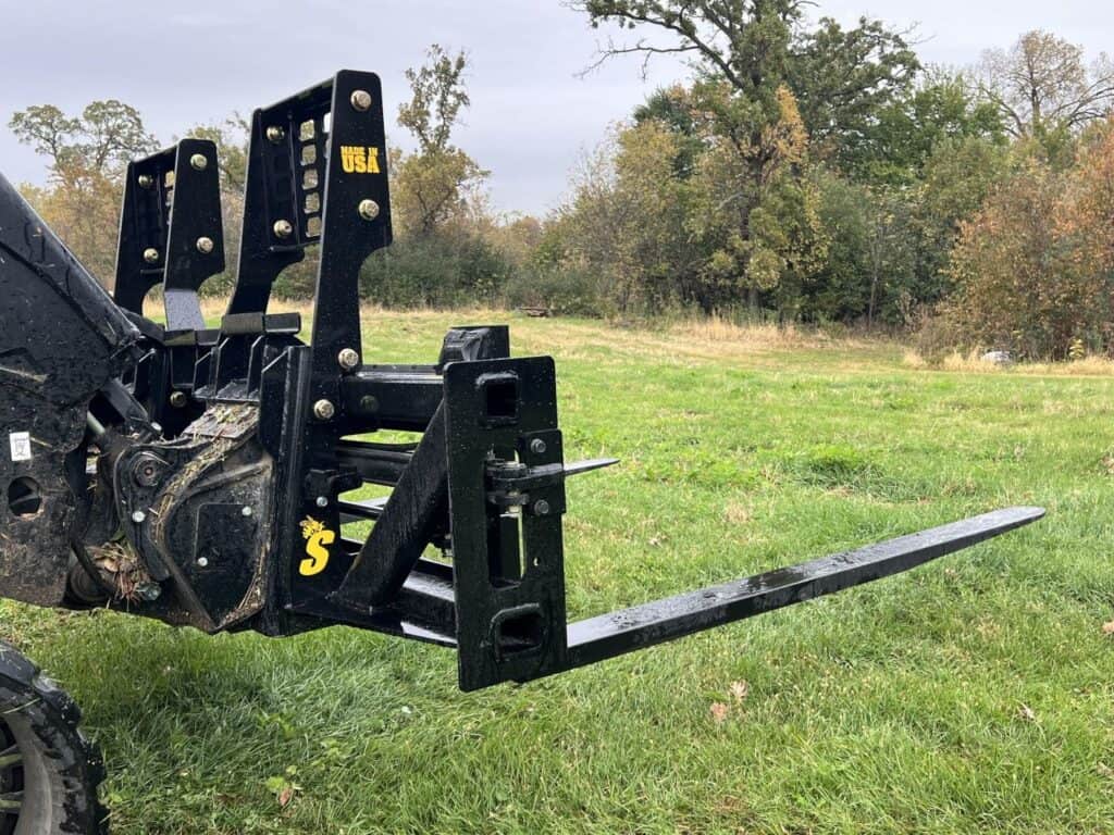 Side view of Stinger PF3H 72 inch hydraulic pallet forks on JCB compact track loader