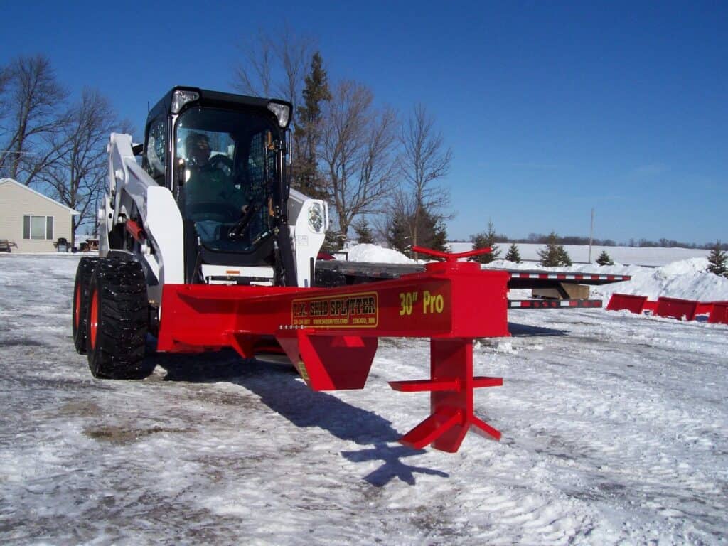 TM Manufacturing Pro 2 skid steer log splitter mounted on Bobcat in winter conditions