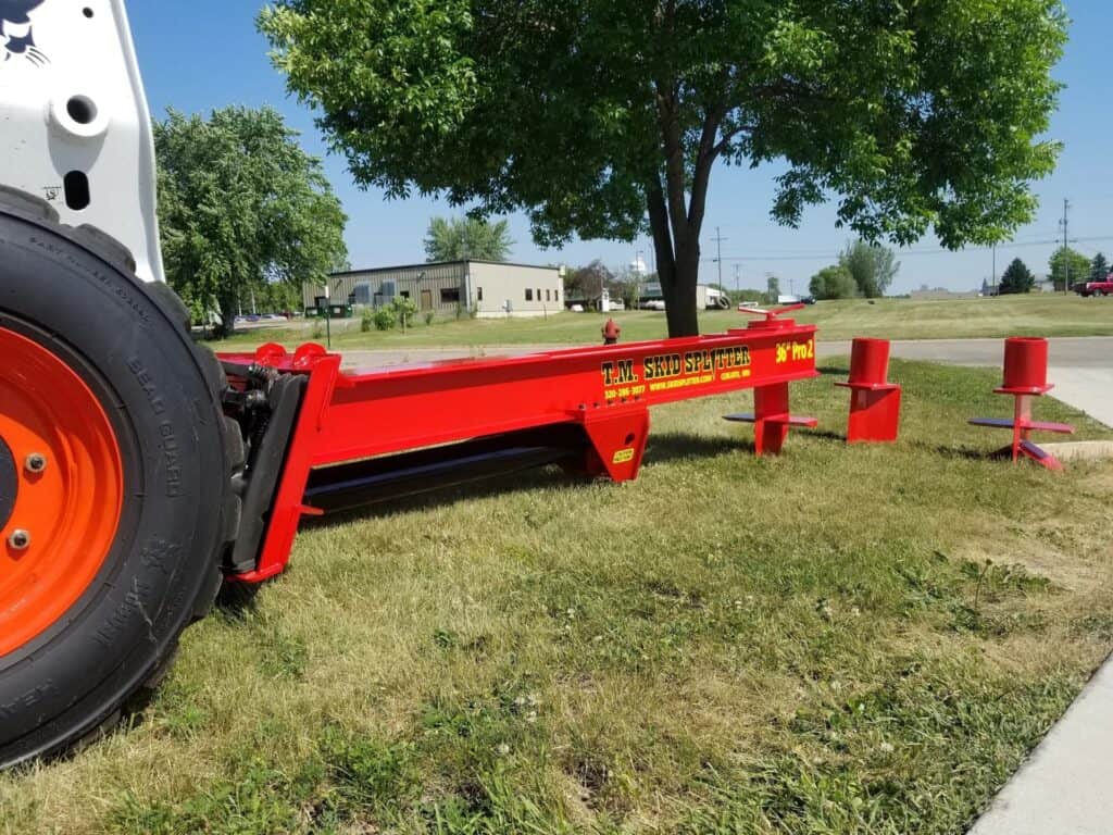 Side view of TM Manufacturing Pro 2 skid steer log splitter attachment outdoors