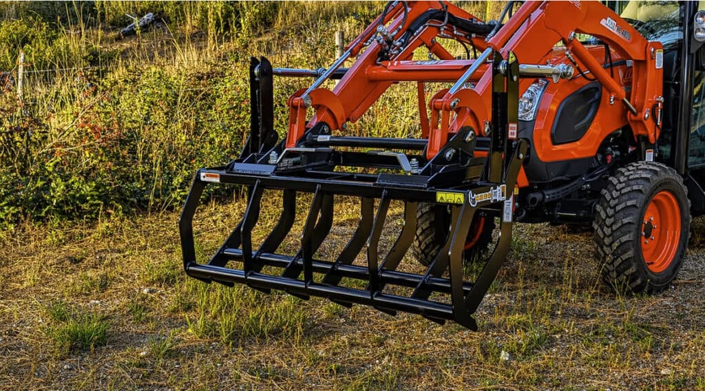 Front view of the ANBO CLASP-IT mechanical grapple closed on a Kioti compact tractor loader