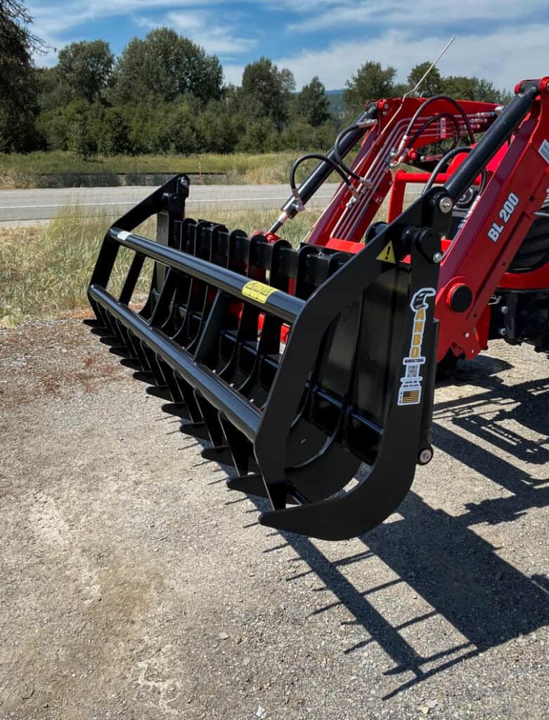 ANBO GR45 grapple rake on a Branson tractor shown from the side with hydraulic cylinders and curved grapple tines