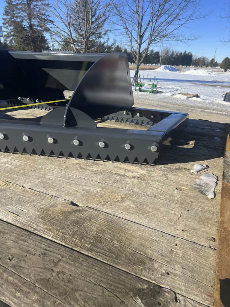 Close-up of a replaceable serrated blade on the ECHO 86 inch skid steer ice scraper and scarifier