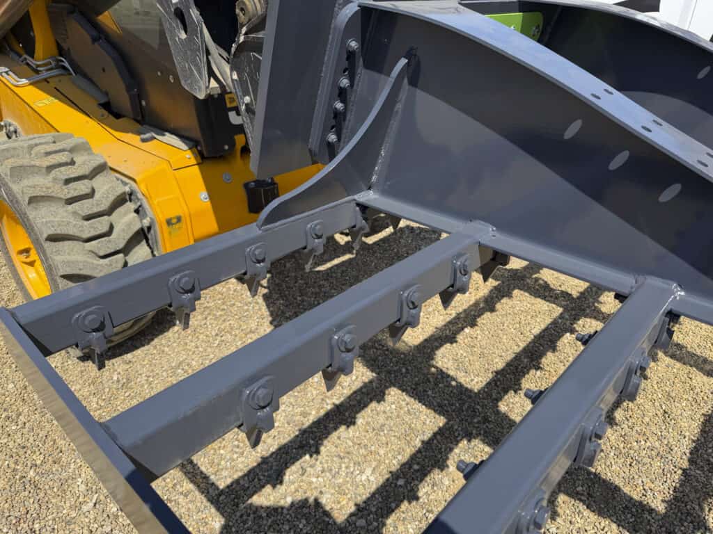 Close-up of the ECHO 92 inch skid steer landscape rake showing the bolted teeth and reinforced steel tooth bars