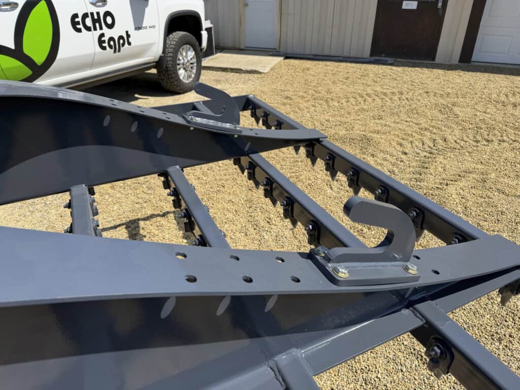 Top view of the ECHO 92 inch skid steer drag landscape rake showing the heavy steel frame, hooks and tooth bars