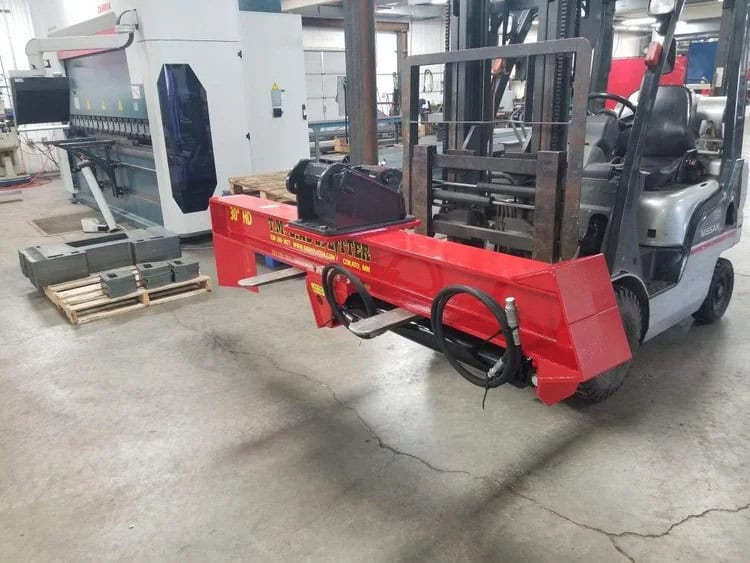 TM Manufacturing 30 inch HD excavator log splitter shown in the shop with hydraulic hoses and coupler mount