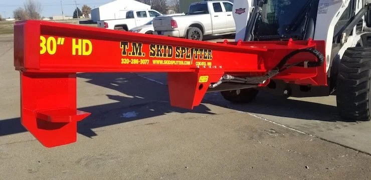 TM Manufacturing 30 inch HD skid steer log splitter attached to a compact track loader showing the heavy duty beam and wedge
