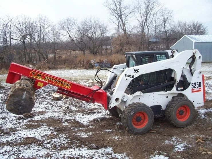 Bobcat skid steer carrying a large log round with the TM Manufacturing Pro 1 log splitter