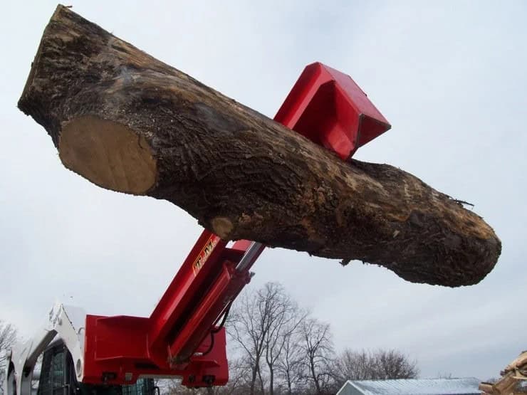 TM Manufacturing Pro 1 skid steer log splitter lifting a large log with the splitter beam raised