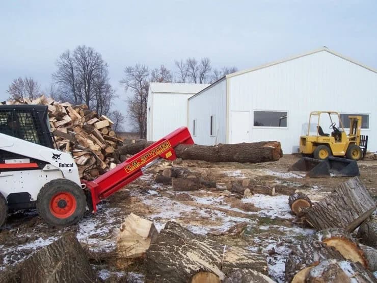 TM Manufacturing Pro 1 skid steer log splitter lifting a long log high for repositioning