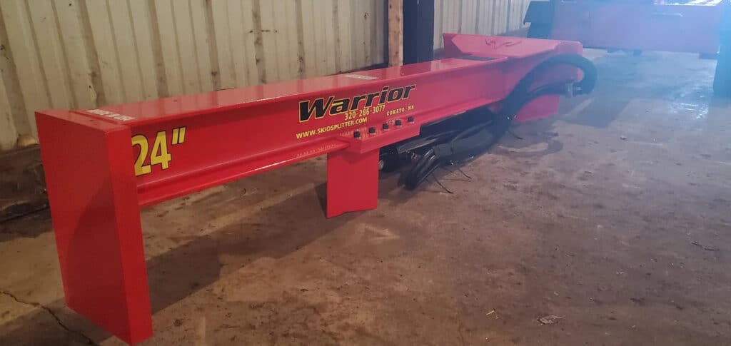 TM Manufacturing Warrior 24 inch skid steer log splitter shown from an angle inside the manufacturing shop