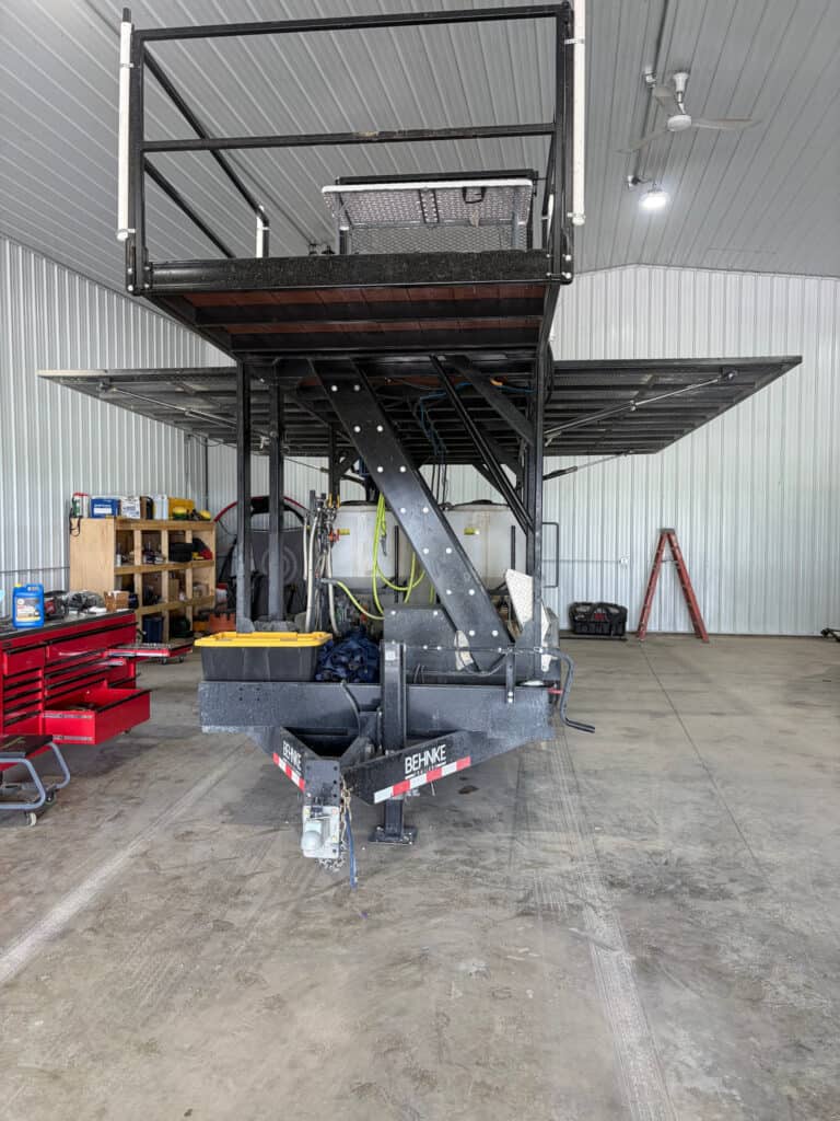 Front view of the ECHO SS Drone Dock trailer platform with elevated safety-railed deck and both mesh wings deployed