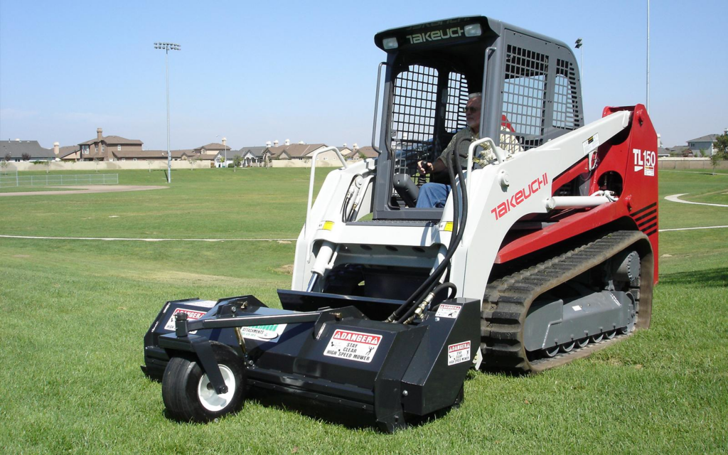 BrushHound 72F Skid Steer Flail Mower mowing grass with a 72" cutting width and front caster wheel.