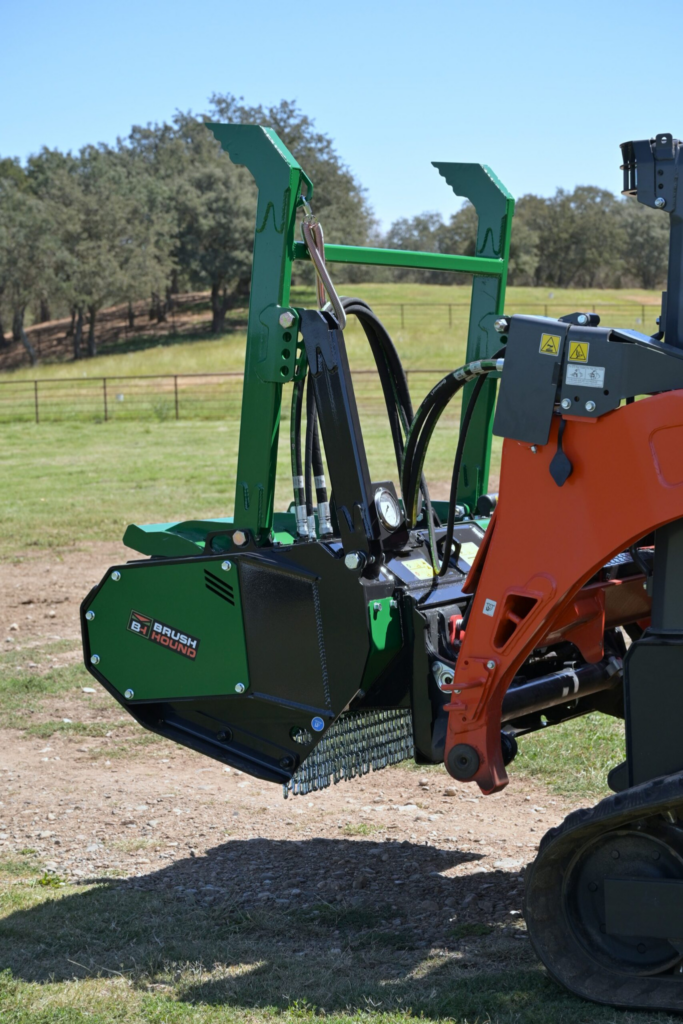 BrushHound FHX66 Defender Forestry Mulcher mounted on a skid steer showing the side housing and tree bumper.