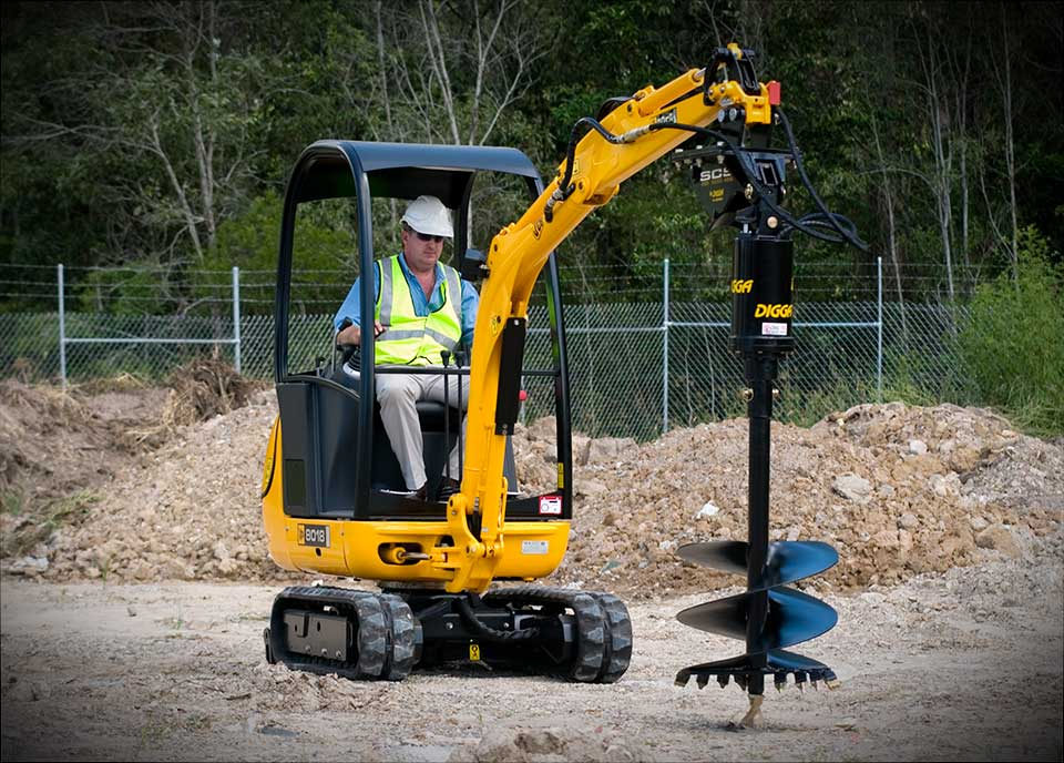 Digga mini excavator auger drive mounted on a compact excavator at a construction job site