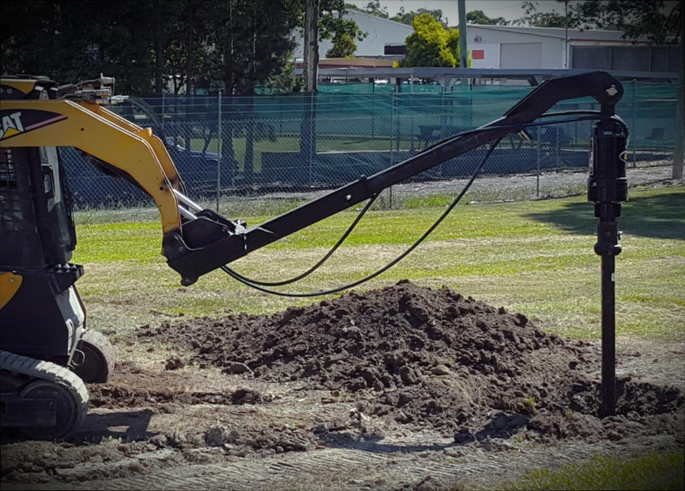 Digga TPE auger drive on a compact track loader drilling on a job site