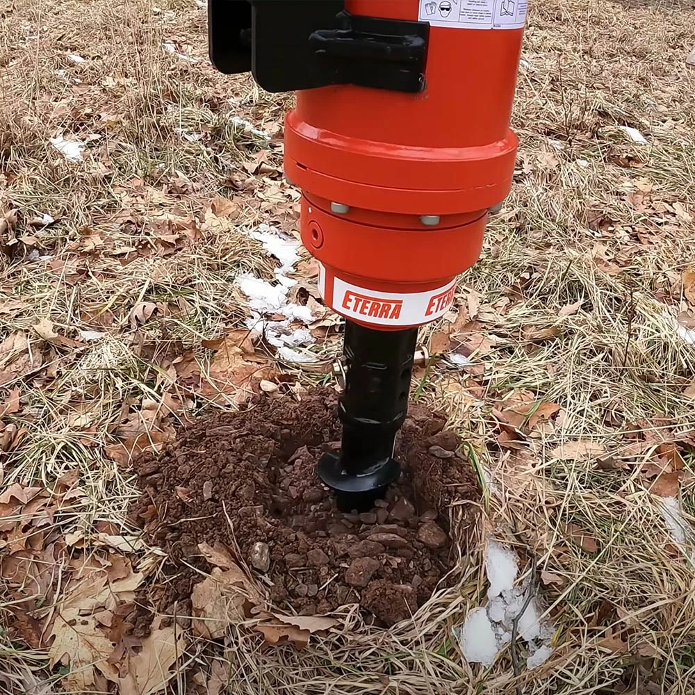 Eterra excavator auger drive drilling into soil with an auger bit attached