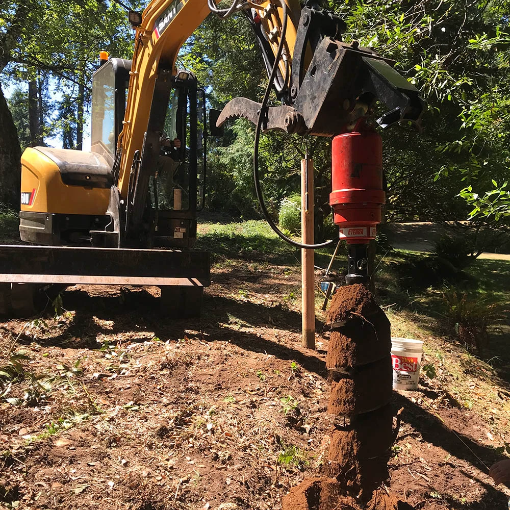 Eterra excavator auger drive drilling a post hole with a compact excavator