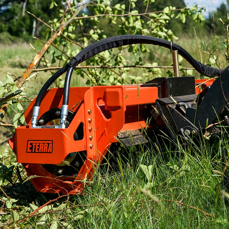 Eterra Sidewinder mini skid steer flail mower clearing brush and overgrown vegetation