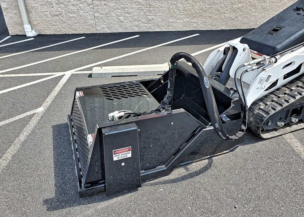 Ideal Rockaway 4415 mini skid steer landscape rake showing hydraulic hoses and bucket
