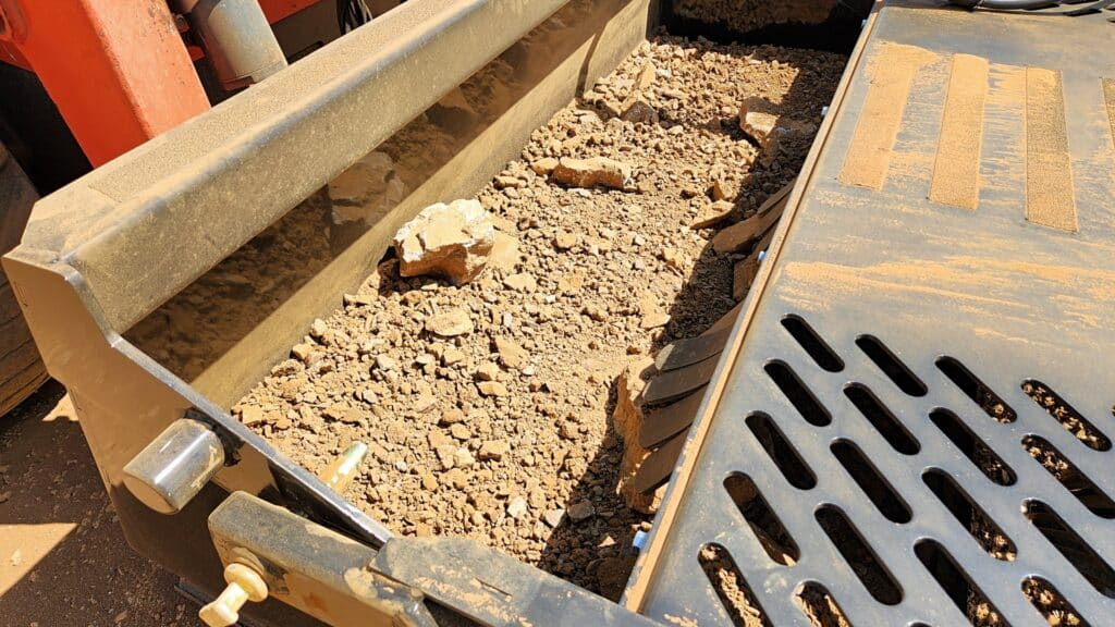 Ideal Rockaway 7415 skid steer rock rake collection bucket holding rocks and debris