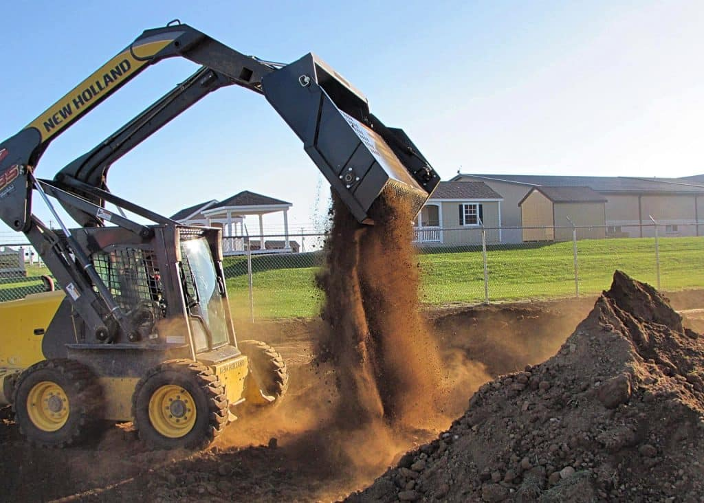 Ideal Rockaway 7415 skid steer rock rake dumping collected rocks and soil