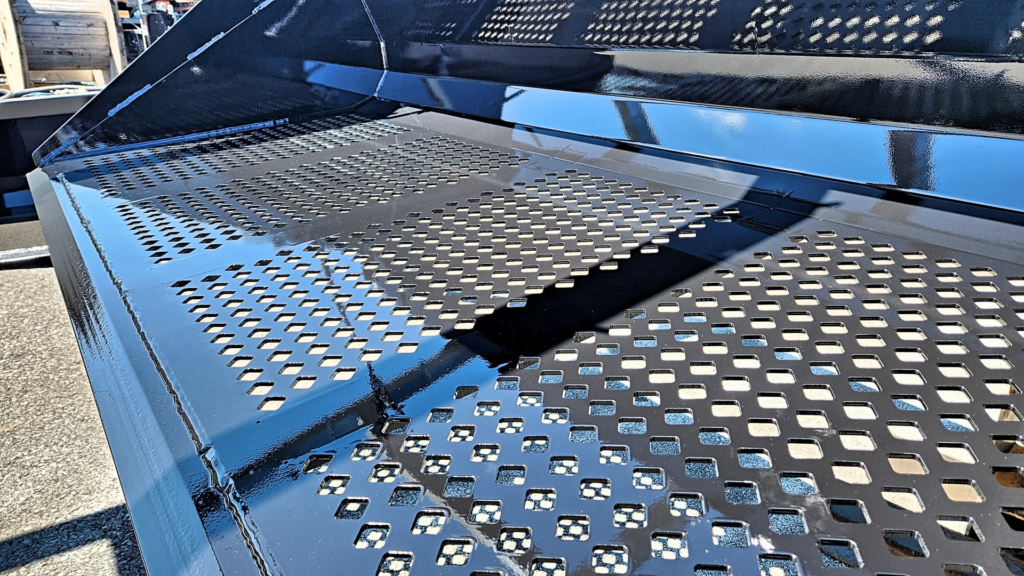 Close-up of the Ideal Rockaway Screening Bucket showing the 3/4-inch diamond-shaped screening holes and reinforced steel floor