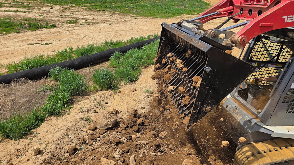 Ideal Rockaway skid steer rock bucket sifting loose soil from rocks and debris