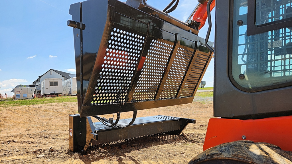 Ideal Rockaway Skid Steer Screening Bucket mounted beneath a raised Rockaway landscape rake hood on a skid steer