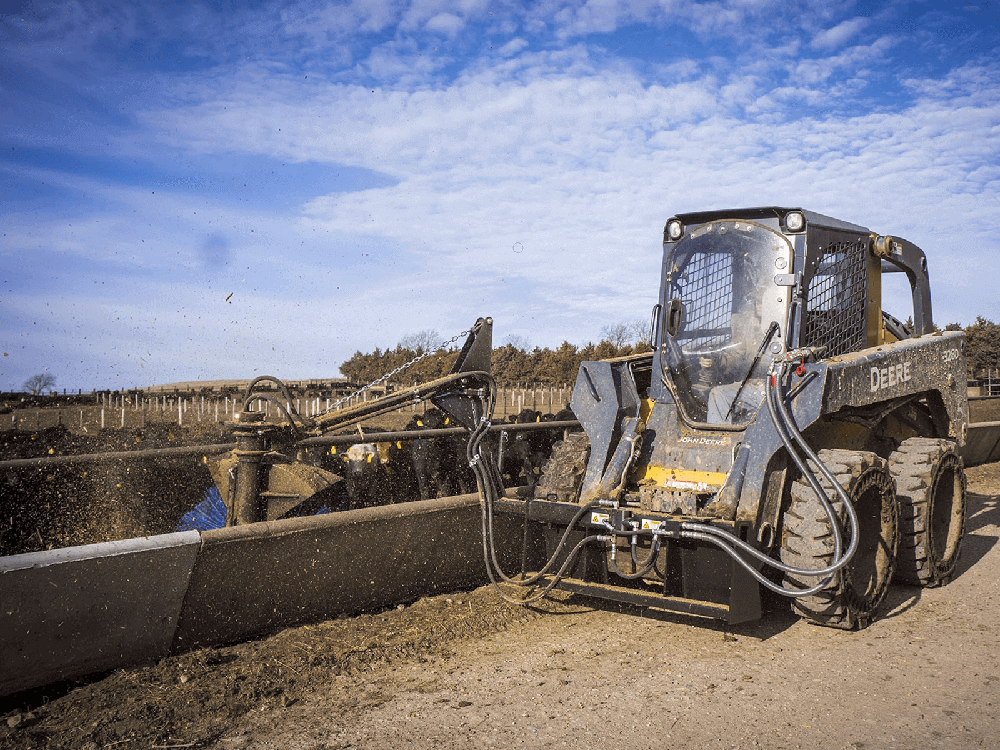 Maxx Attachments Feed Bunk Sweeper cleaning debris along a livestock feed bunk
