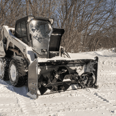 Bobcat skid steer equipped with a Prime Attachments Skid Steer Snow Blower during winter snow removal