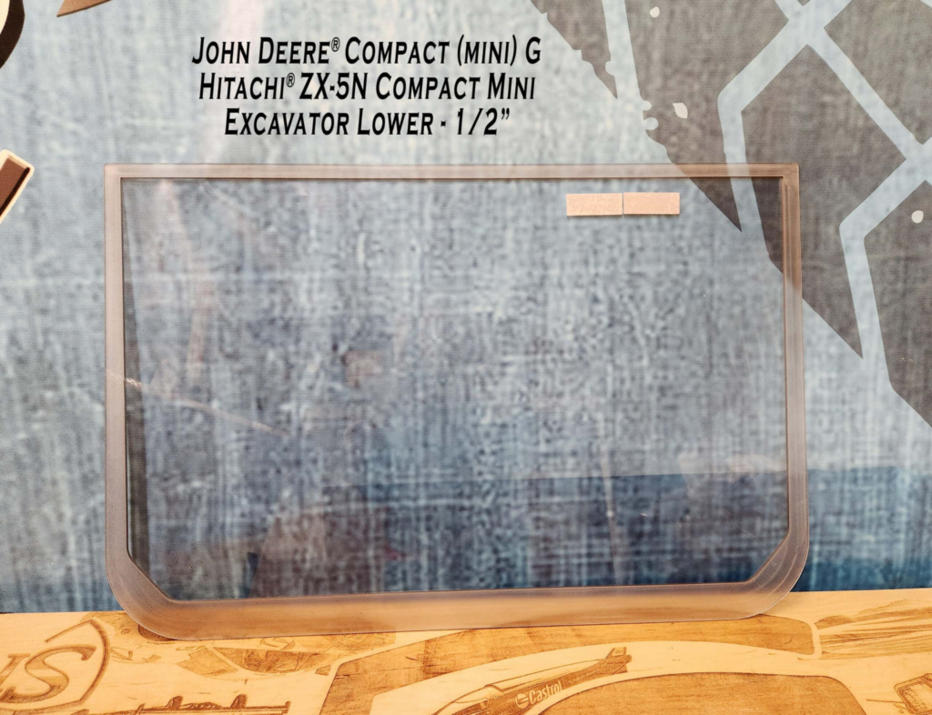 Front view of SHIELDS John Deere Compact G & P Series polycarbonate lower excavator windshield showing the full window shape.