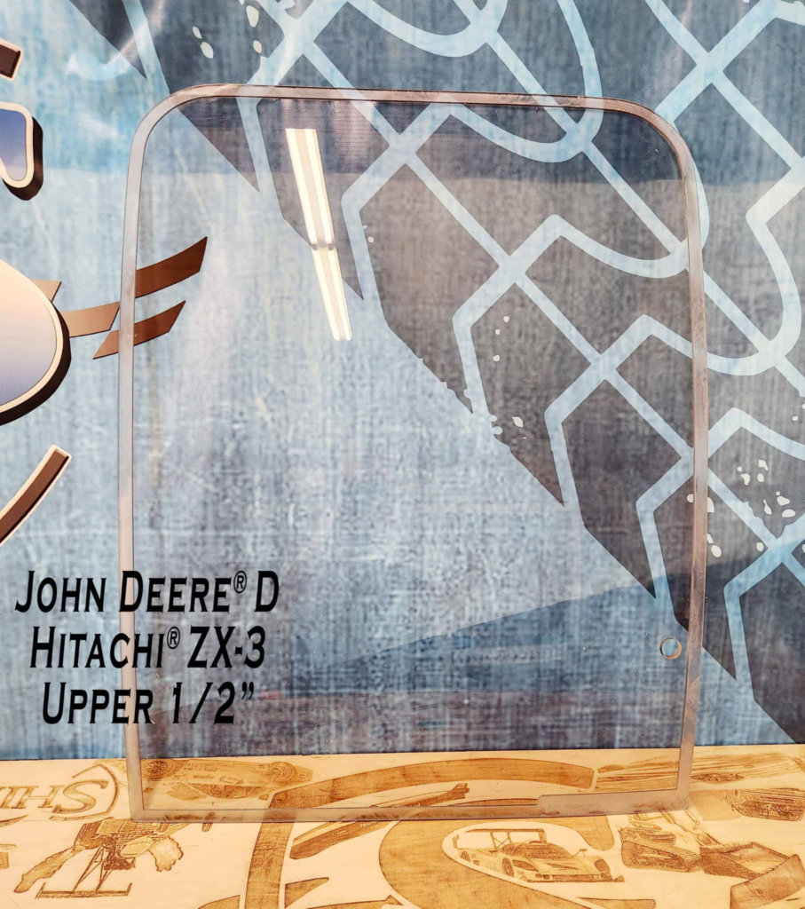 Front view of SHIELDS John Deere D Series polycarbonate upper excavator windshield showing the curved OEM-style shape.