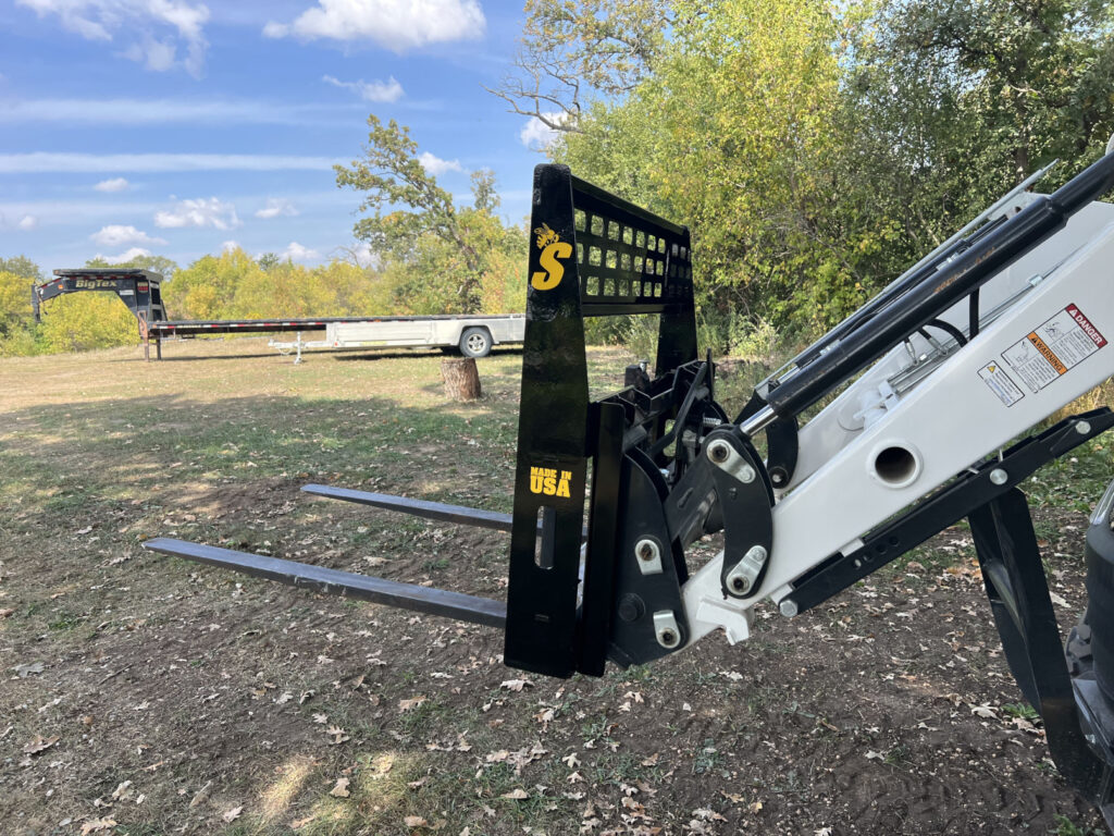 Stinger CPF compact pallet forks side view on Bobcat compact tractor showing fork carriage and loader linkage
