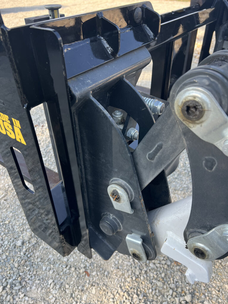 Close-up of Stinger CPF bolt-on mount and loader linkage on compact tractor pallet fork frame