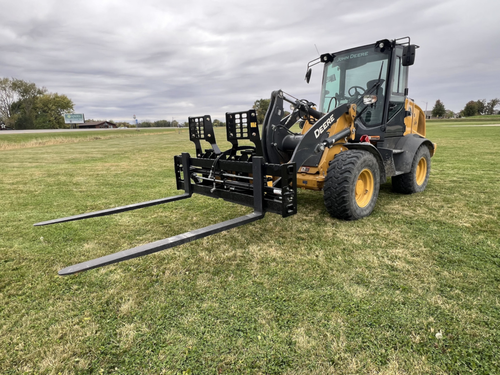 Front angle view of Stinger PF3H hydraulic pallet forks mounted on a John Deere wheel loader