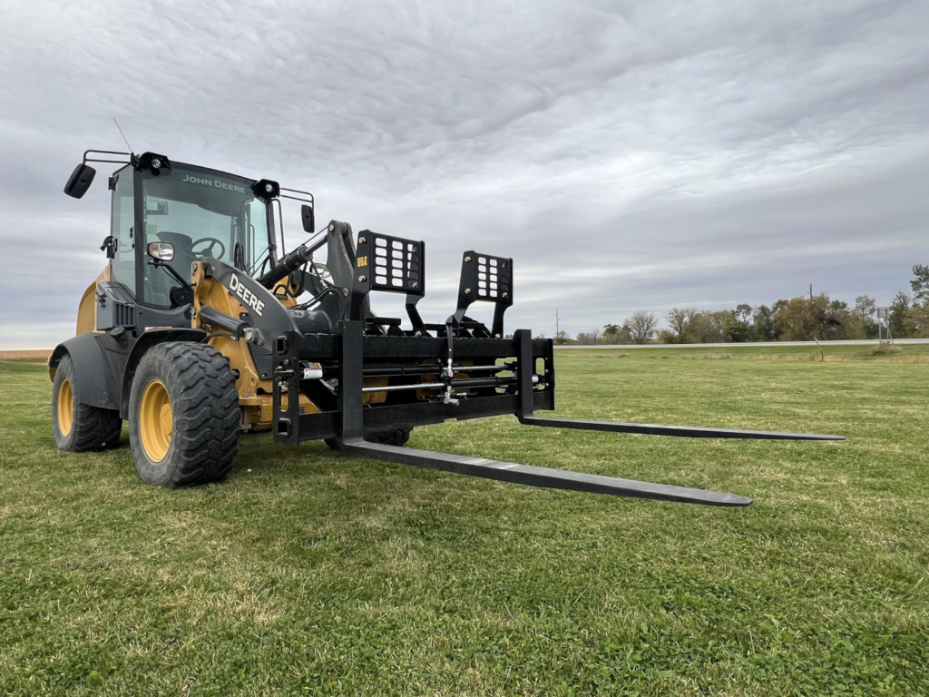 Wide view of Stinger PF3H hydraulic pallet forks mounted on a John Deere wheel loader